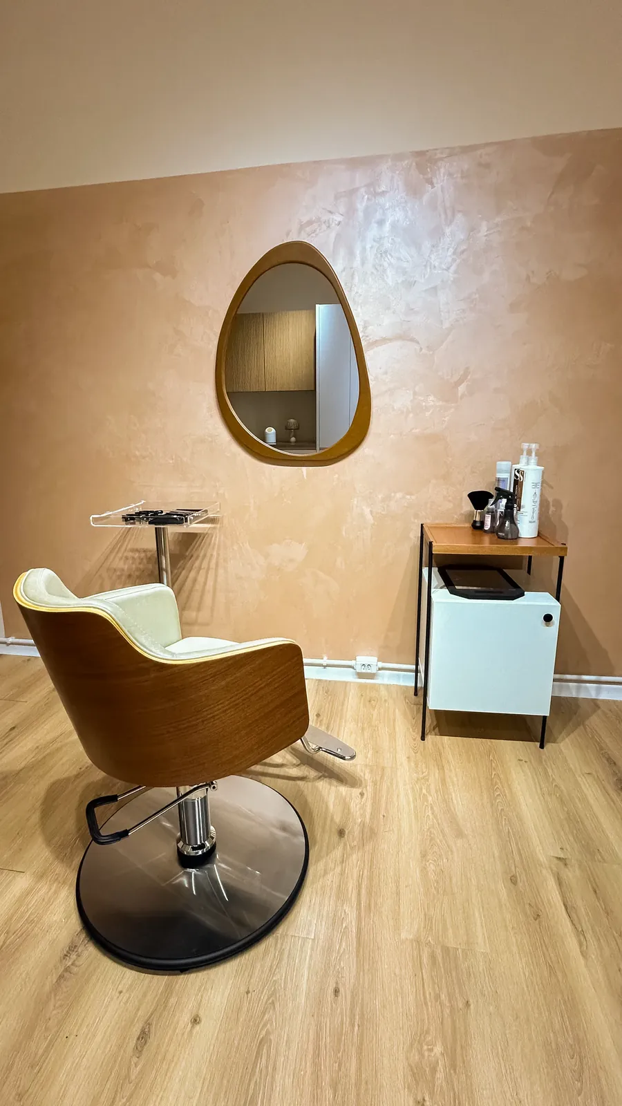 Sala de corte com a cadeira de madeira e o espelho orgânico