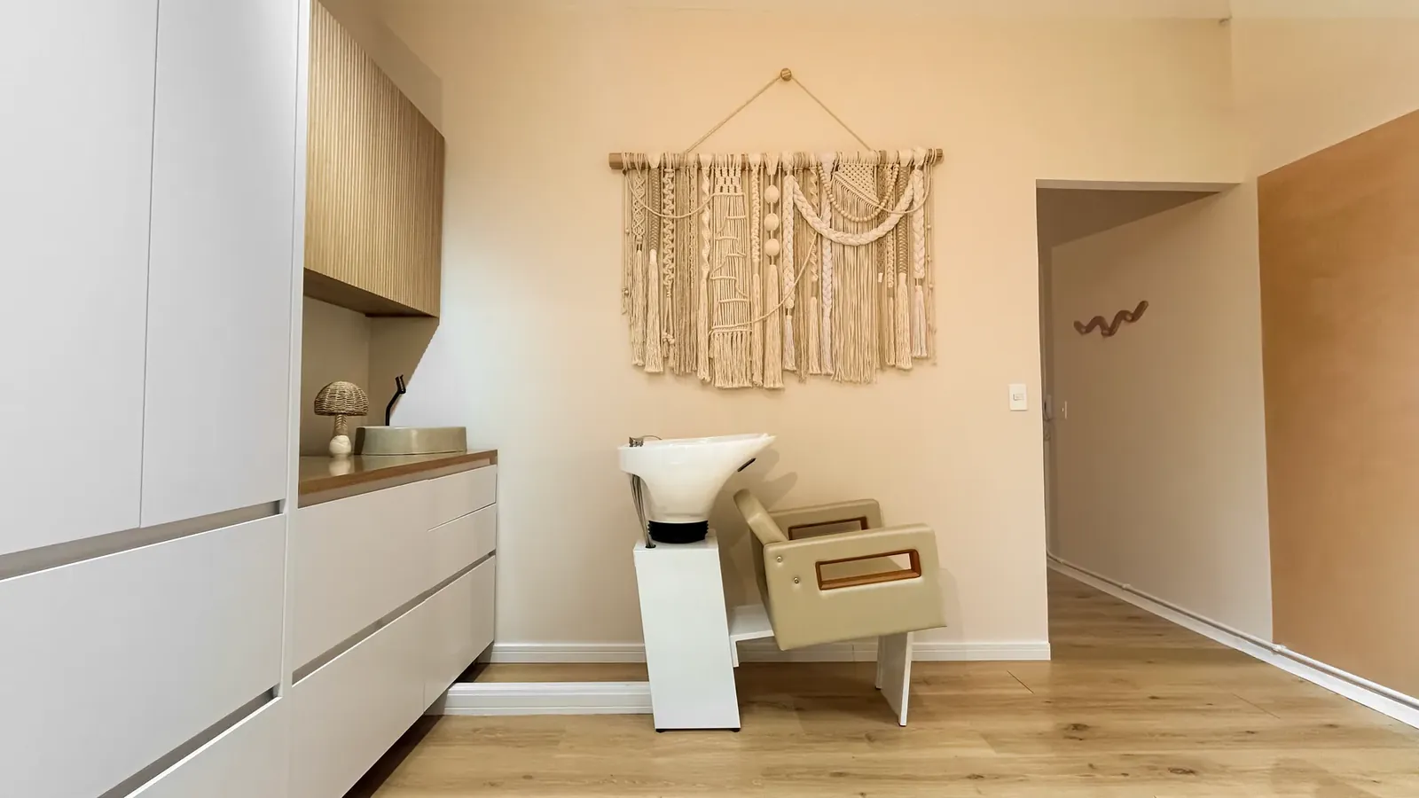 Sala de atendimento com lavatório, armários e painel de macramê