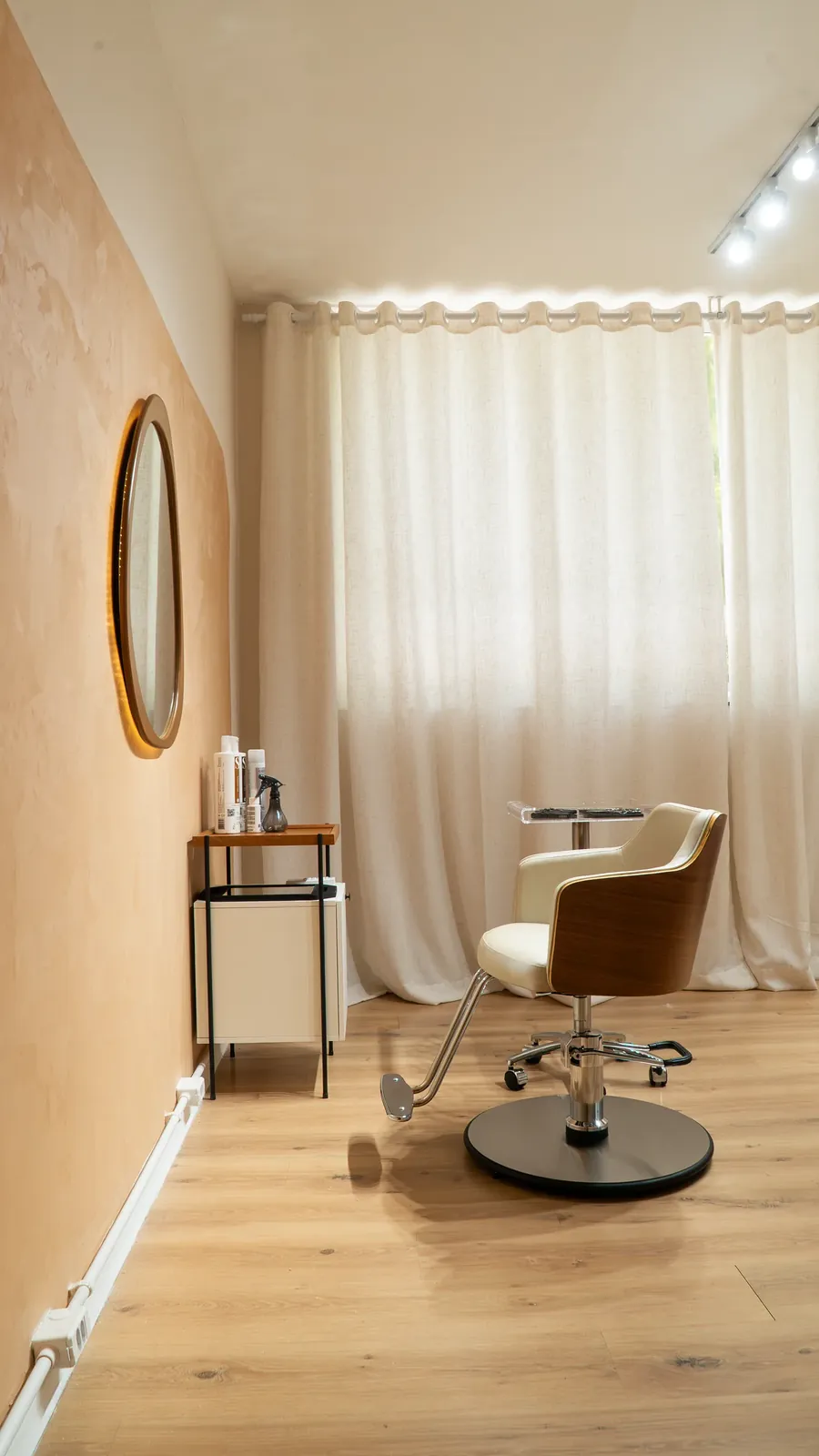 Sala de corte com cadeira de madeira e cortina de linho