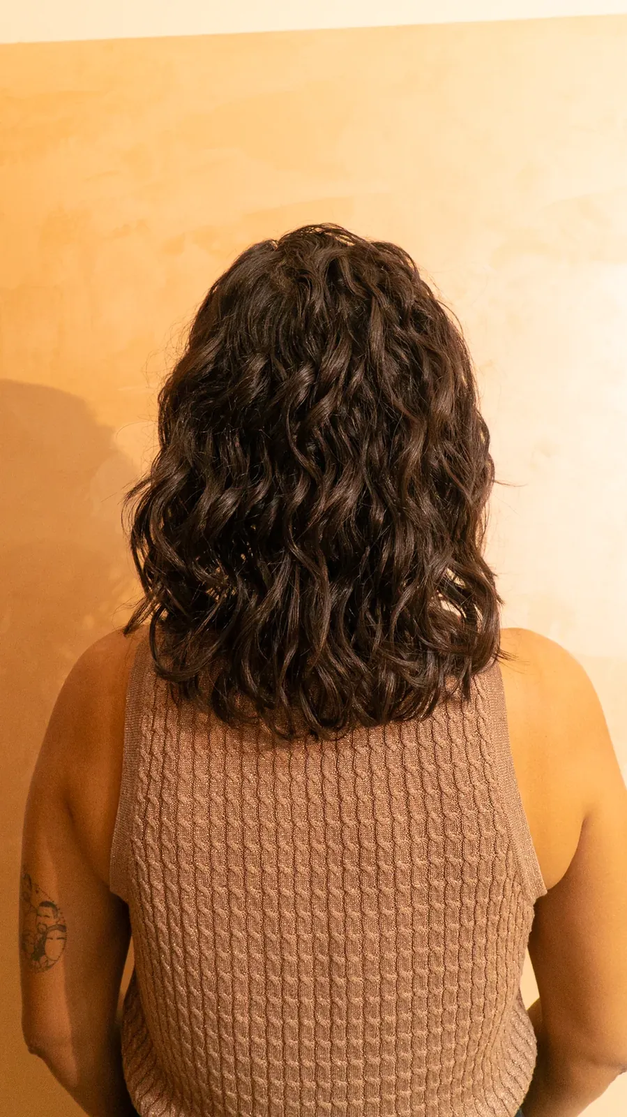 Cabelo ondulado castanho finalizado, visto de costas