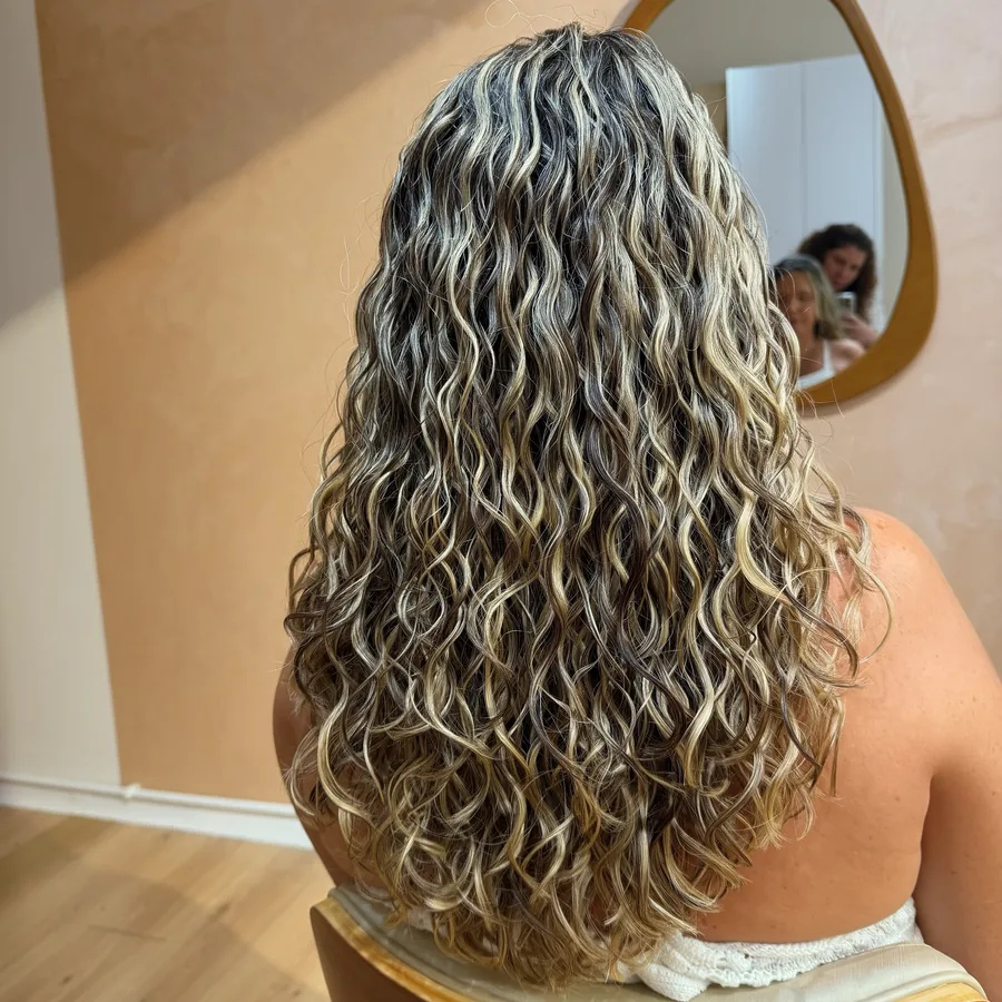 Cabelo ondulado longo, iluminado e saudável, da raiz às pontas, após o tratamento
